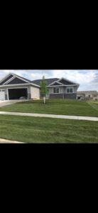 Completed landscaping service with manicured lawn and a single tree